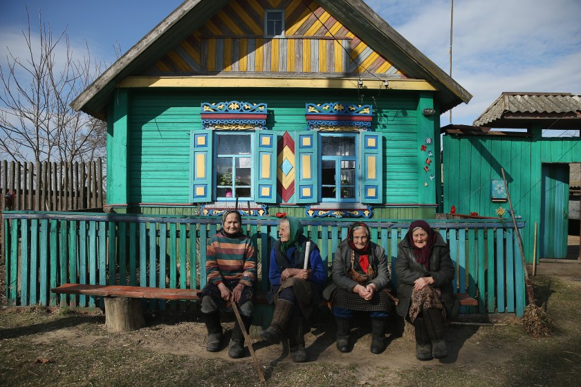 CHACHERSK, BELARUS - APRIL 04: Elderly women sit next to a traditional house in the village of Pokats on April 4, 2016 near Chachersk, Belarus. Chachersk and Pokats, both located in south-eastern Belarus, are in a zone designated as still contaminated to varying degrees with radiation from the 1986 Chernobyl nuclear disaster, especially caesium-137. Numerous areas nearby are off-limits to visitors and signs on the edges of forests warn of radiation and urge people not to pick berries and mushrooms. While the United Nations Scientific Committee on the Effects of Radiation (UNSCEAR) claims that Chernobyl radiation in the region no longer poses a significant health risk, local physicians and researchers say the ongoing threat is still very real and that a dramatically high rate of children are born with weak immune systems and heart rhythm disorders. According to the Belarus government it currently spends 5% of its annual budget dealing with the consequences of Chernobyl and 20% of arable land in Belarus remains too contaminated for use. (Photo by Sean Gallup/Getty Images)