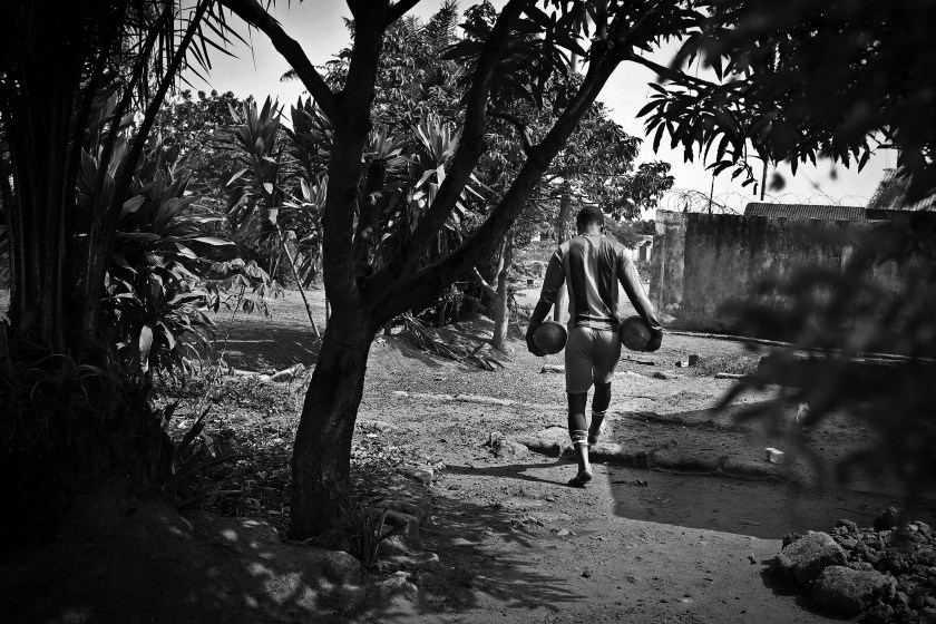 Erison Turay, walks to the soccer pitch to practice with the Ebola Survivor's Soccer Club, near his house, in the city of Kenema, 190 miles east of the capital Freetown, Sierra Leone, Tuesday, April 21, 2015. Last year, 38 members of Erison's family died from the deadly Ebola virus, which has killed over 11,000 across West Africa. Erison founded the Ebola Survivor's Soccer Club as a support network for survivors and a means to battle negative stigmas in the community. (Photo Credit/Tara Todras-Whitehill for the New York Times) World Press Photo 2016 Contest