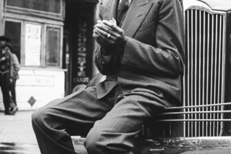 Baseball player Satchel Paige, looking dapper, lighting his cigarette while sitting on front bumper of large car.  (Photo by George Strock/The LIFE Picture Collection/Getty Images)