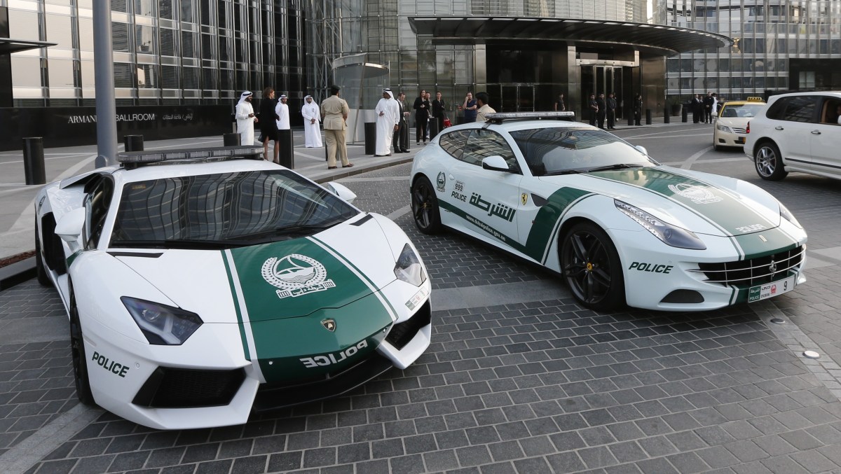 A picture taken on April 25, 2013 shows Lamborghini (L) and Ferrari police vehicles at the foot of the Burj Khalifa tower in the Gulf emirate of Dubai. Two weeks after introducing the Lamborghini police car, Dubai Police has introduced a Ferrari to the fleet, to further strengthen the "image of luxury and prosperity" of the emirate. AFP  PHOTO /  KARIM SAHIB        (Photo credit should read KARIM SAHIB/AFP/Getty Images)