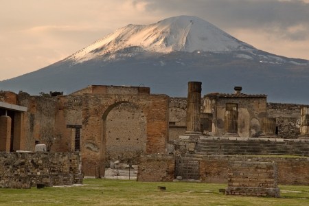 The sun begins to set on the snow capped Mount Vesuvius still overlooking Temple of Jupiter standing in the forum of Pompeii. (DHuss/Creative RF/Getty Images)