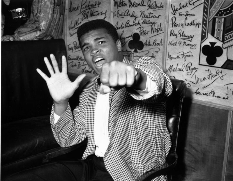 27th May 1963: Supremely confident American boxer Cassius Clay holds up five fingers in a prediction of how many rounds it will take him to knock out British boxer Henry Cooper. (Photo by Kent Gavin/Keystone/Getty Images)