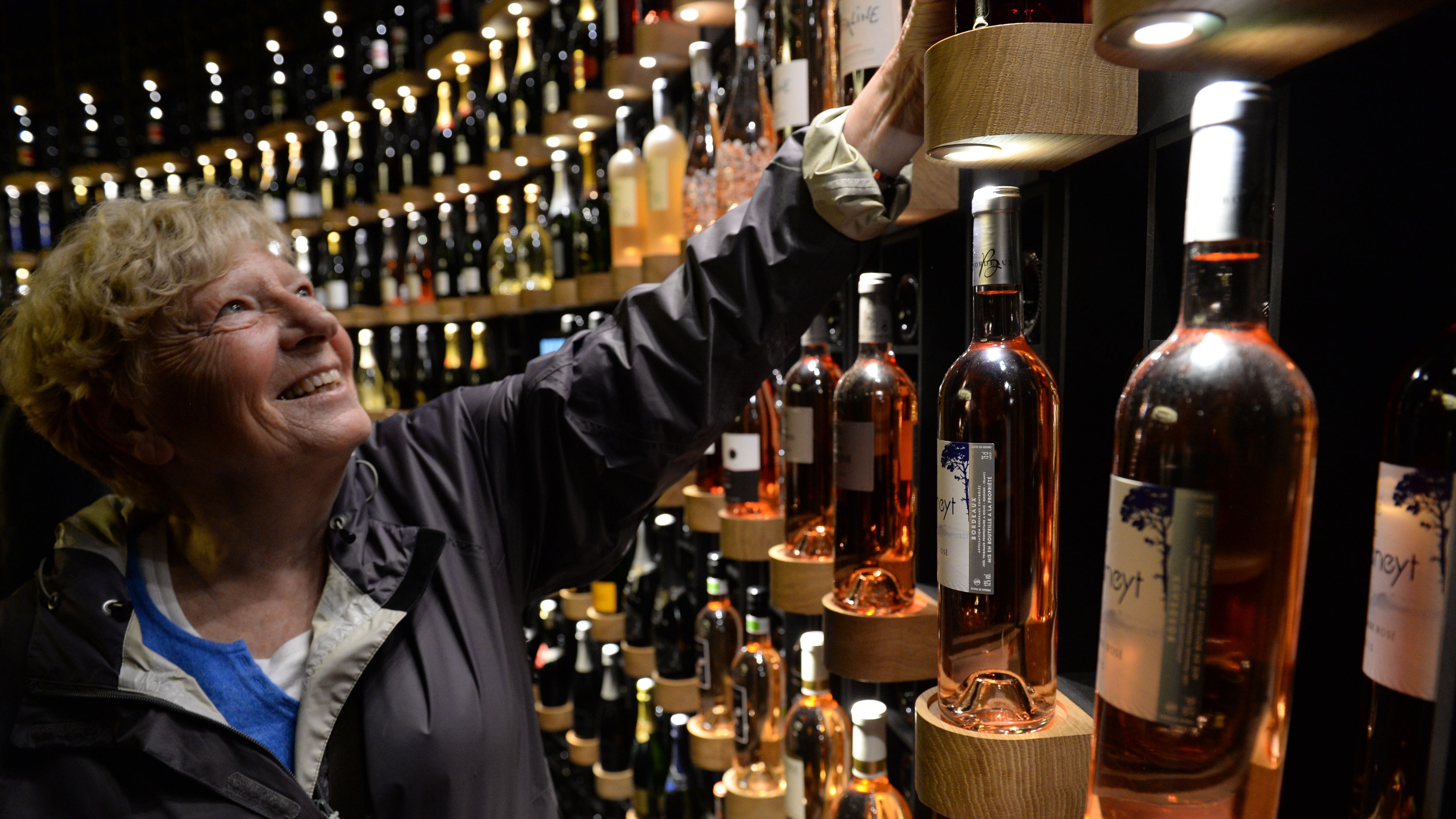 A woman looks at bottles of wine as she visits La Cite du Vin (Wine Museum) as it opens its doors to the public in Bordeaux on June 1, 2016.
La Cite du Vin opened its doors to the public on June 1. The 13 350 m2 compound offers thematics areas about the history and civilisations of wine around the world with digital and sensory exhibits. / AFP / MEHDI FEDOUACH (Photo credit should read MEHDI FEDOUACH/AFP/Getty Images)