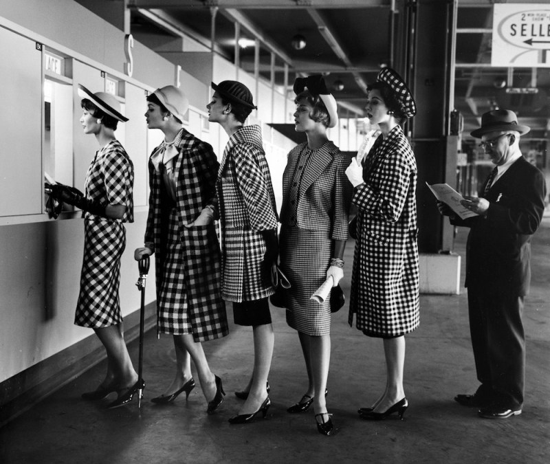 Five models wearing fashionable dress suits at a race track betting window, at Roosevelt Raceway. (Nina Leen/The LIFE Picture Collection)