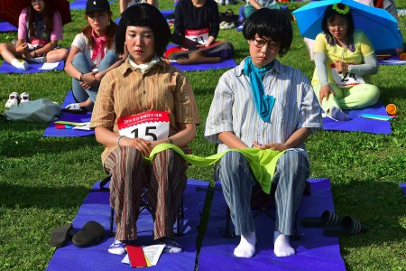 Dozens of citizens take part in Seoul's "space-out" competition in which participants are required to sit idly without talking, sleeping, eating, or using any electronic devices, at a riverside park in Seoul on May 22, 2016.
The competition has gained popularity in South Korea since local artists organised the first edition in Seoul in 2014 as a satire of modern life dominated by social media and smartphones. / AFP / JUNG YEON-JE        (Photo credit should read JUNG YEON-JE/AFP/Getty Images)