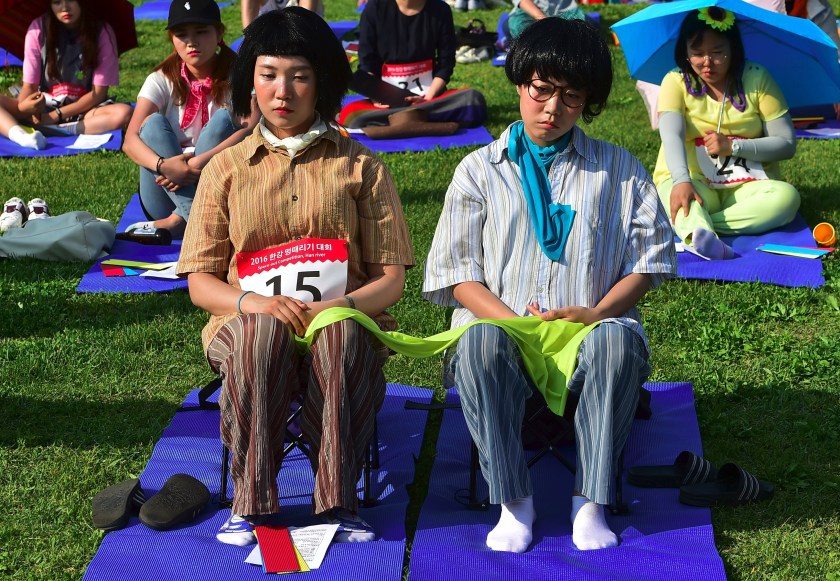 Dozens of citizens take part in Seoul's "space-out" competition in which participants are required to sit idly without talking, sleeping, eating, or using any electronic devices, at a riverside park in Seoul on May 22, 2016. The competition has gained popularity in South Korea since local artists organised the first edition in Seoul in 2014 as a satire of modern life dominated by social media and smartphones. / AFP / JUNG YEON-JE (Photo credit should read JUNG YEON-JE/AFP/Getty Images)