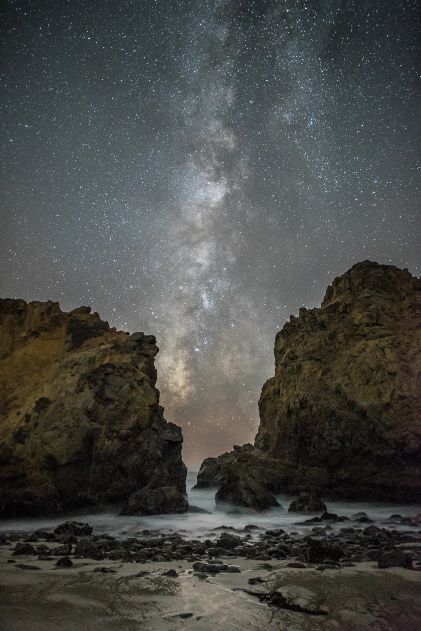 Our galaxy, the Milky Way, stretches across the night sky between two of the imposing rocks at Pfeiffer State Beach, near Big Sur, California. (Rick Whitacre)