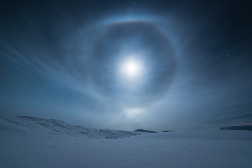 A mesmerising lunar halo forms around our natural satellite, the Moon, in the night sky above Norway. The halo, also known as a moon ring or winter halo, is an optical phenomenon created when moonlight is refracted in numerous ice crystals suspended in the atmosphere. (Tommy Richardson)