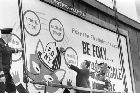 What Smokey the Bear is to the prevention of forest fires, City officials hope Foxy the Fireman will be to human safety. Fire Commissioner Thompson (c) puts the finishing touches to one of 250 billboard signs posted around the city to warn against home fire hazarsd. Looking on are Asst. Chief Charles McKeogh (l) and Foxy himself, played by fireman Barney Schmeltzer. (Photo by William Jacobellis/New York Post Archives / (c) NYP Holdings, Inc. via Getty Images)