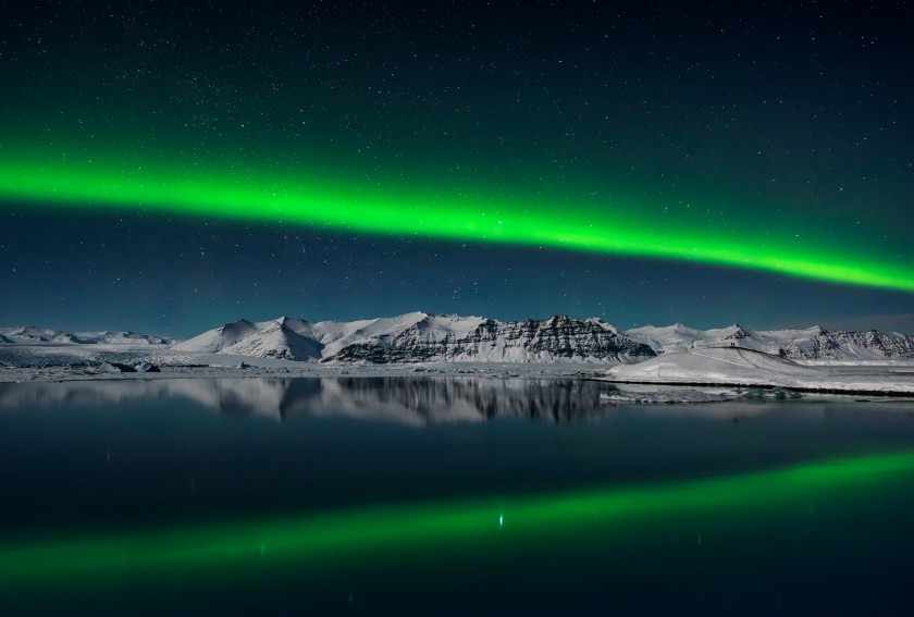 A couple takes in the awe-inspiring sight of the Northern Lights streaking across the night sky over the lagoon at Jokulsarlon, Iceland on Valentine’s night of 2016. (Giles Rocholl)