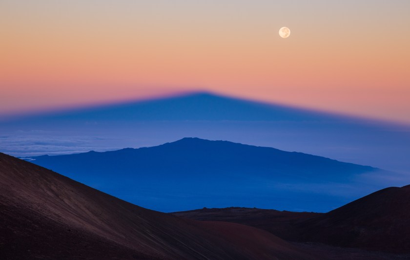 The shadow of Manua Kea, the highest peak in the state of Hawaii, is projected by the rising sun over the volcano, Hualalai, whilst the Full Moon soars above them, higher again. (Sean Goebel)
