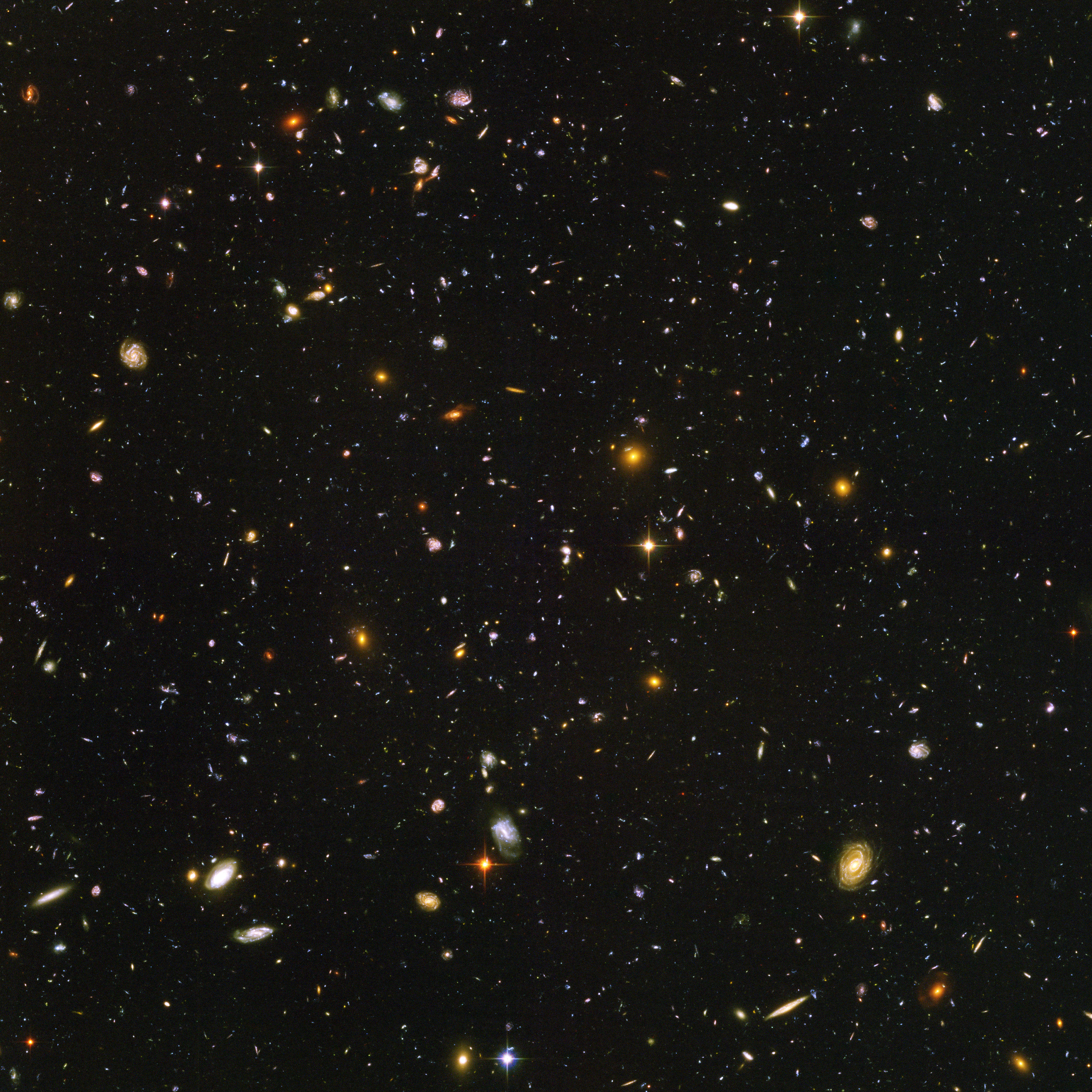 Galaxies, galaxies everywhere - as far as the NASA/ESA Hubble Space Telescope can see. This view of nearly 10,000 galaxies is the deepest visible-light image of the cosmos. Called the Hubble Ultra Deep Field, this galaxy-studded view represents a "deep" core sample of the universe, cutting across billions of light-years. The snapshot includes galaxies of various ages, sizes, shapes, and colours. The smallest, reddest galaxies, about 100, may be among the most distant known, existing when the universe was just 800 million years old. The nearest galaxies - the larger, brighter, well-defined spirals and ellipticals - thrived about 1 billion years ago, when the cosmos was 13 billion years old. In vibrant contrast to the rich harvest of classic spiral and elliptical galaxies, there is a zoo of oddball galaxies littering the field. Some look like toothpicks; others like links on a bracelet. A few appear to be interacting. These oddball galaxies chronicle a period when the universe was younger and more chaotic. Order and structure were just beginning to emerge. The Ultra Deep Field observations, taken by the Advanced Camera for Surveys, represent a narrow, deep view of the cosmos. Peering into the Ultra Deep Field is like looking through a 2.5 metre-long soda straw. In ground-based photographs, the patch of sky in which the galaxies reside (just one-tenth the diameter of the full Moon) is largely empty. Located in the constellation Fornax, the region is so empty that only a handful of stars within the Milky Way galaxy can be seen in the image. In this image, blue and green correspond to colours that can be seen by the human eye, such as hot, young, blue stars and the glow of Sun-like stars in the disks of galaxies. Red represents near-infrared light, which is invisible to the human eye, such as the red glow of dust-enshrouded galaxies. The image required 800 exposures taken over the course of 400 Hubble orbits around Earth. The total amount of exposure time was 11.3 days,