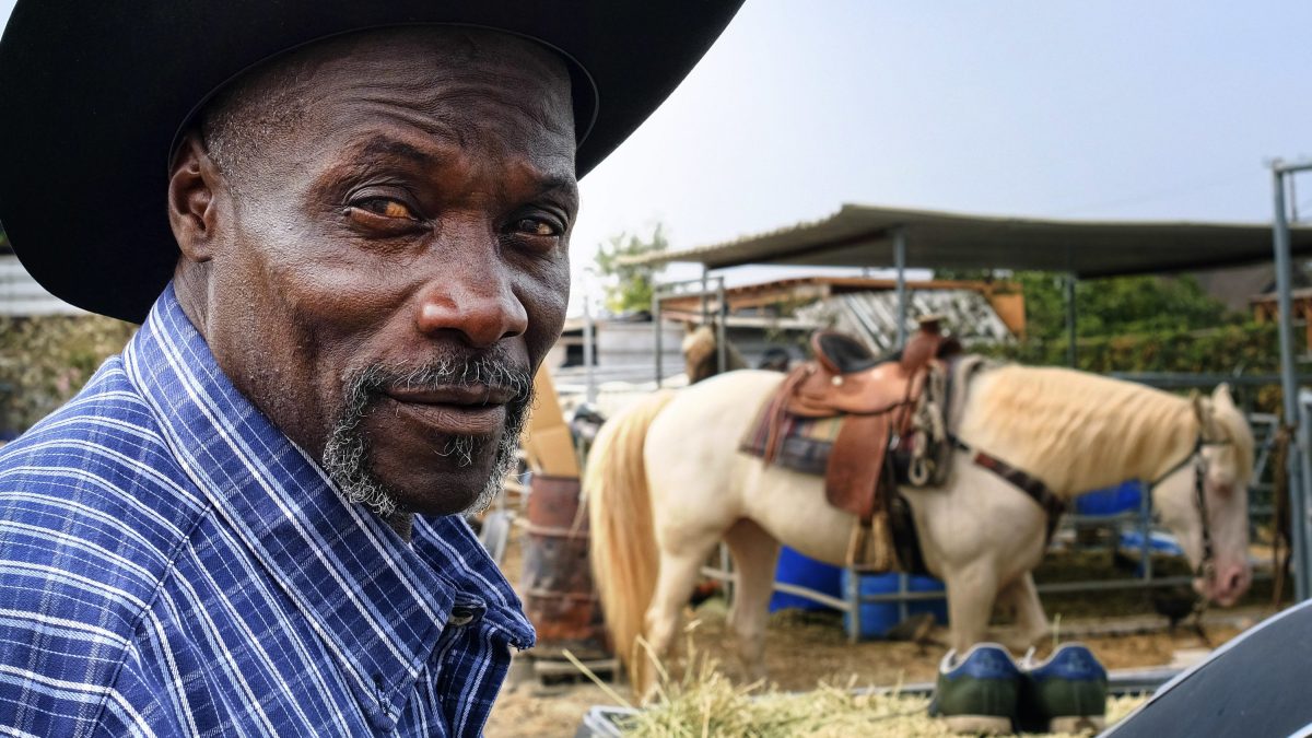 Ivory McCloud poses for a photo with his horse, Diamond, at his stable in the backyard of a home in Compton, Calif., on Sunday, Aug. 7, 2016. "I've got 40 years in this, man," the 56-year-old horseman says. "My dad was a cowboy. I'm a cowboy. I grew up in Compton. I live in Compton and I've been training horses since I was a kid." (AP Photo/Richard Vogel)