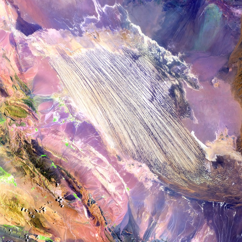 A bold paint stroke on a busy purple canvas is actually part of the Dasht-e Lut Desert in southeastern Iran. The linear features are kaluts, huge rocky formations shaped by wind erosion. The streamlined forms vary in size, but some kaluts stretch more than 100 kilometers (62 miles).(USGS/NASA)