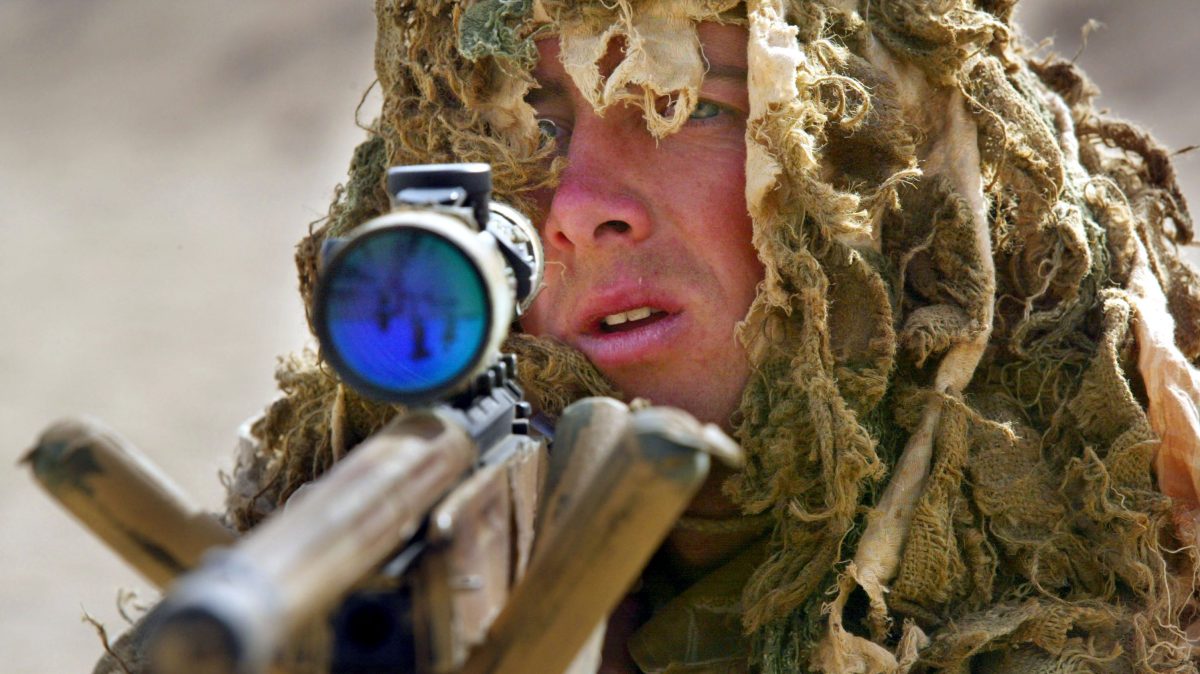Marine Alasdair Kane, a British Royal Marine soldier from the 42nd Commando Lima Brigade, goes through training exercises in camouflage using a .338 sniper rifle March 10, 2003 in the desert 70 kilometers from Kuwait city near the Iraqi border. (Paula Bronstein/Getty Images)