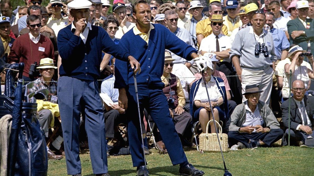 AUGUSTA, GA - APRIL 1966:  (L-R) Ben Hogan and Arnold Palmer smoke as they wait in front of a gallery to play their tee shot on the second hole during the 1966 Masters Tournament at Augusta National Golf Club held April 7-11, 1966 in Augusta, Georgia. (Photo by Augusta National/Getty Images)