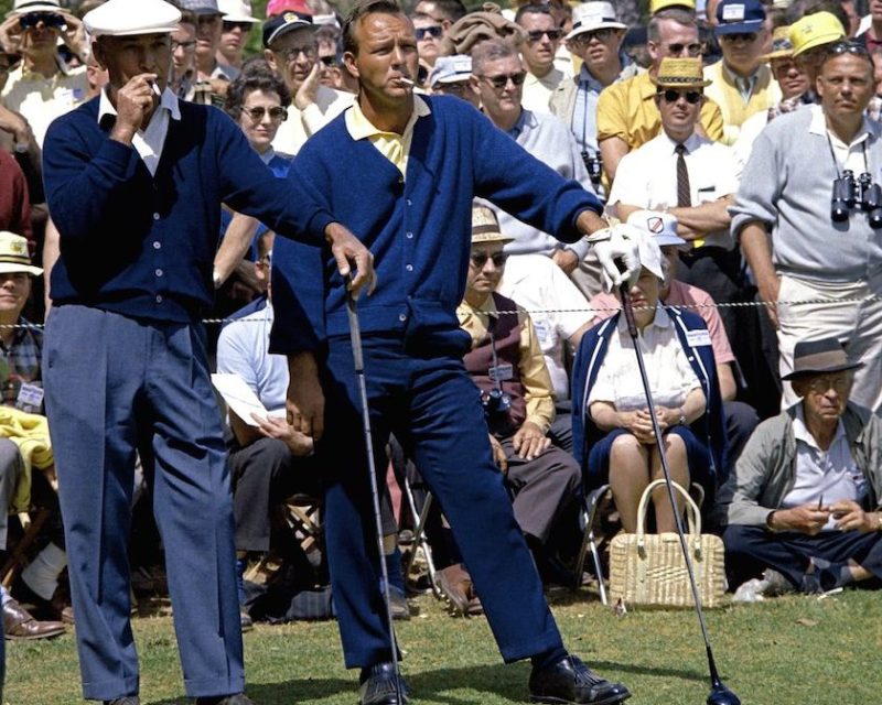 AUGUSTA, GA - APRIL 1966: (L-R) Ben Hogan and Arnold Palmer smoke as they wait in front of a gallery to play their tee shot on the second hole during the 1966 Masters Tournament at Augusta National Golf Club held April 7-11, 1966 in Augusta, Georgia. (Photo by Augusta National/Getty Images)