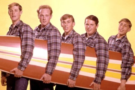 LOS ANGELES - AUGUST 1962: Rock and roll band "The Beach Boys" pose for a portrait with a surfboard in August 1962 in Los Angeles, California. (L-R) Brian Wilson, Mike Love,  Dennis Wilson, Carl Wilson, David Marks. (Photo by Michael Ochs Archives/Getty Images)