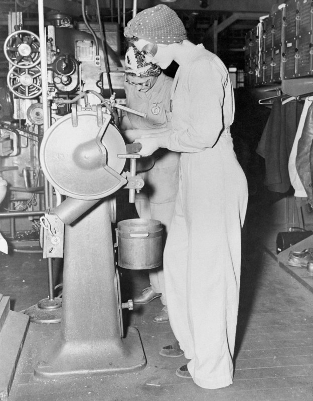 Though not dressed for a dance, Naomi Parker, foreground, and Frances Johnson look alright to us. Their clothes are the proper ones for women workers at the Alameda Naval Air station. For safety and efficiency (of the males employees, maybe?) the girls are ordered to wear slack suits, heavy shoes, no jewelry and turbans during work hours.