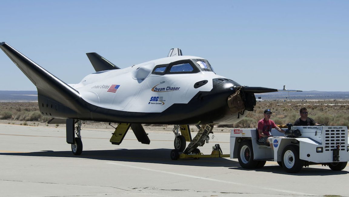 In this June 27, 2013 photo provided by NASA, Sierra Nevada Corp. engineers and technicians prepare the Dream Chaser engineering test vehicle for tow tests at NASA's Dryden Flight Research Center in California. On Thursday, Jan. 14, 2016, NASA announced the Sierra Nevada Corp. will join SpaceX and Orbital ATK in launching cargo to the International Space Station. These flights, yet to be finalized, will run through 2024. (Ken Ulbrich/NASA via AP)