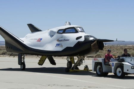 In this June 27, 2013 photo provided by NASA, Sierra Nevada Corp. engineers and technicians prepare the Dream Chaser engineering test vehicle for tow tests at NASA's Dryden Flight Research Center in California. On Thursday, Jan. 14, 2016, NASA announced the Sierra Nevada Corp. will join SpaceX and Orbital ATK in launching cargo to the International Space Station. These flights, yet to be finalized, will run through 2024. (Ken Ulbrich/NASA via AP)