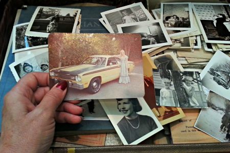A woman is looking through a trunk of old photos.  (Getty Images)