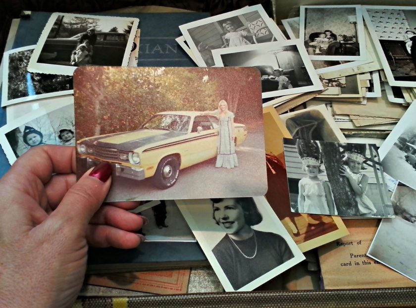 A woman is looking through a trunk of old photos. (Getty Images)