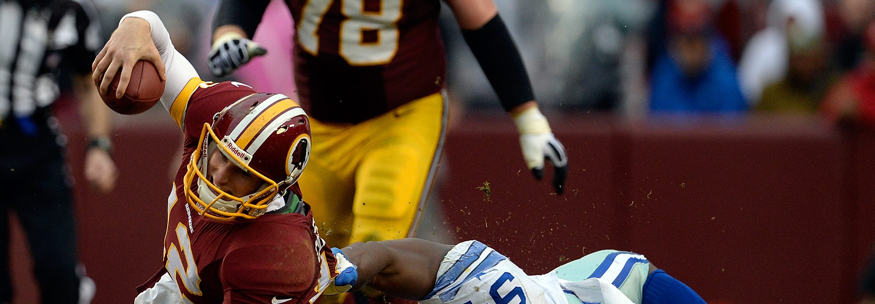 Quarterback Kirk Cousins #12 of the Washington Redskins is tackled by DeMarcus Ware #94 of the Dallas Cowboys in the second half during an NFL game at FedExField on December 22, 2013 in Landover, Maryland. (Patrick McDermott/Getty Images)