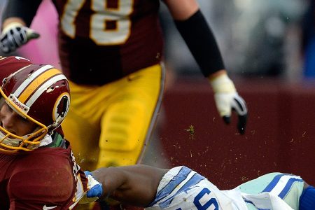Quarterback Kirk Cousins #12 of the Washington Redskins is tackled by DeMarcus Ware #94 of the Dallas Cowboys in the second half during an NFL game at FedExField on December 22, 2013 in Landover, Maryland.  (Patrick McDermott/Getty Images)