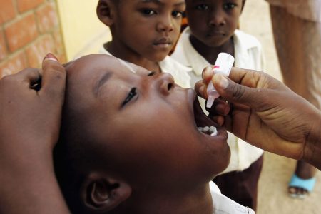 A Nigerian schoolboy is vaccinated against polio during a mass nationwide polio inoculation April 12, 2005, in Kano, Nigeria. (Chris Hondros/Getty Images)