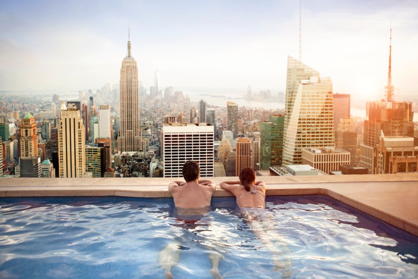 Couple relaxing in swimming pool on hotel rooftop in New York City. (Getty Images)