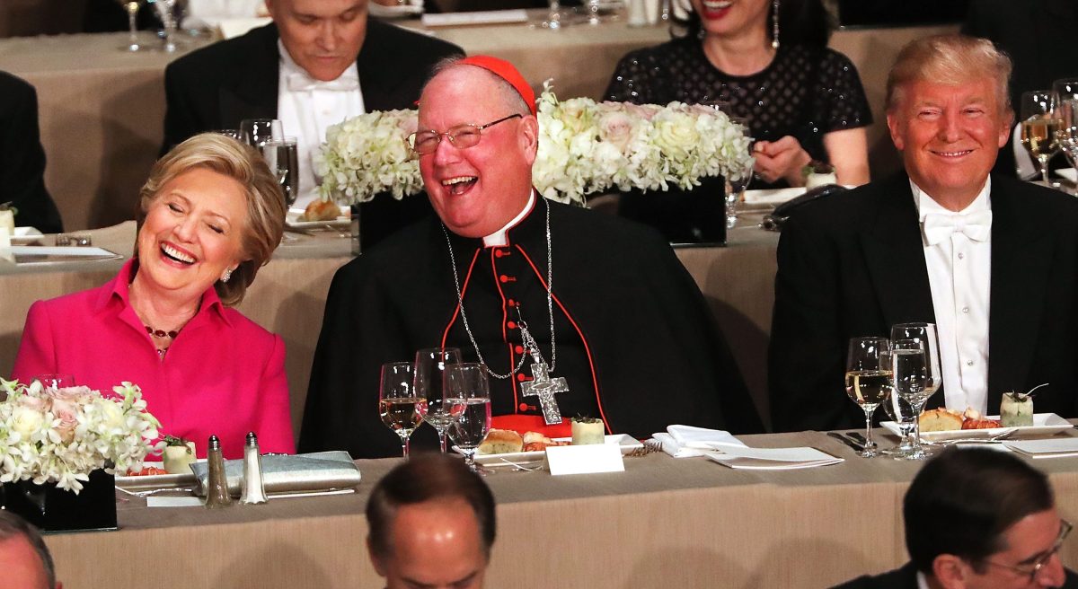 Cardinal Timothy Dolan sits between, Hillary Clinton and Donald Trump attend the annual Alfred E. Smith Memorial Foundation Dinner at the Waldorf Astoria on October 20, 2016 in New York City.The white-tie dinner, which benefits Catholic charities and celebrates former Governor of New York  Al Smith, has been attended by presidential candidates since 1960 and gives the candidates an opportunity to poke fun at themselves and each other.  (Spencer Platt/Getty Images)