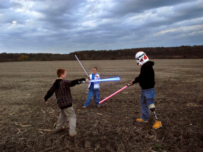 Raymond plays with Star Wars lightsabers with his sons Brady and Riley in Wisconsinduring 2007. (Peter van Agtmael/Magnum Photos)