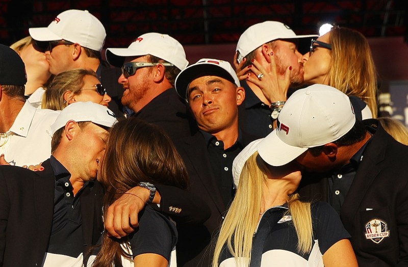 CHASKA, MN - OCTOBER 02: Rickie Fowler of the United States looks on as Kim Johnson, Zach Johnson, J.B. Holmes, Erica Holmes, Jimmy Walker, Erin Walker, Jordan Spieth, Annie Verret, Justine Reed and Patrick Reed celebrate during singles matches of the 2016 Ryder Cup at Hazeltine National Golf Club on October 2, 2016 in Chaska, Minnesota. (Photo by Scott Halleran/PGA of America via Getty Images)