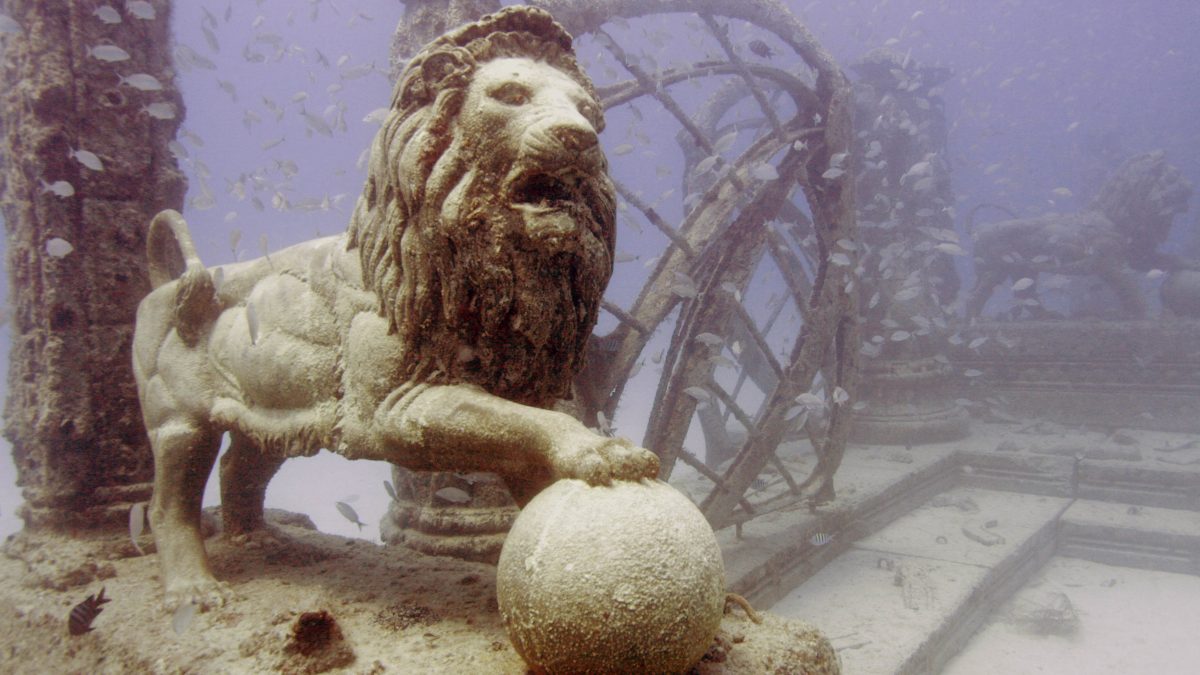 Fish swim near a lion sculpture in the Neptune Memorial Reef Tuesday, April 29, 2008, 3.25 miles off the coast of Key Biscayne, Fla. Creators of the reef hope it will become a memorial for the dead and a diving site. Instead of a burial funeral, people can pay to have their remains placed in one the reef's structures after their death. (AP Photo/Wilfredo Lee)