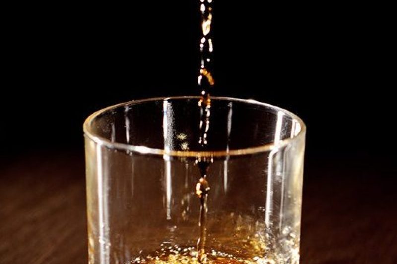 Scotch or bourbon whiskey (or whisky) being poured into a glass with dramatic studio lighting and a black background. (Getty Images)