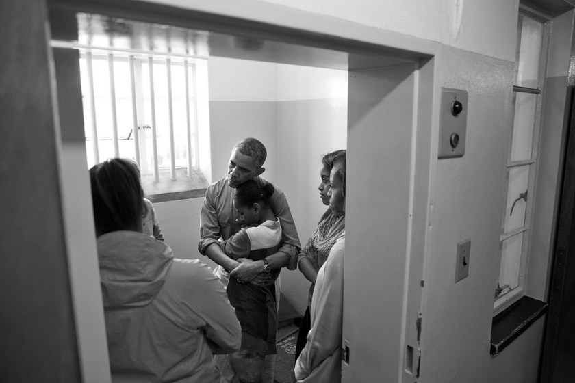 "A quiet moment inside Nelson Mandela's former prison cell as the President embraced Sasha while the Obama family was listening to Ahmed Kathrada recount his years spent imprisoned here on Robben Island in Cape Town, South Africa. Nelson Mandela was imprisoned for 27 years, initially in this prison cell. Kathrada was imprisoned at Robben Island for 18 years." (Official White House Photo by Pete Souza)