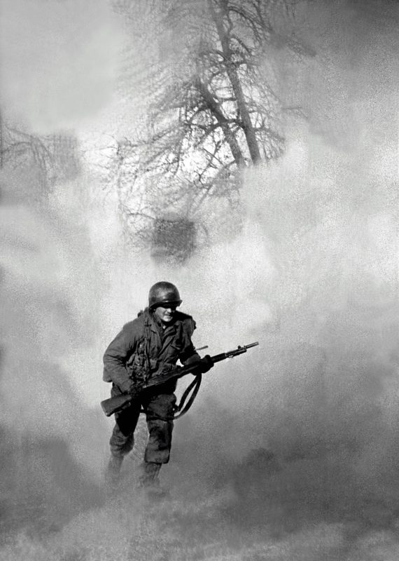 American GI Ivan Parrott is seen running through smoke in no mans land near Neuss, Germany during the Battle for the Rhine, World War II, 1st March 1945. (Tony Vaccaro/Getty Images)