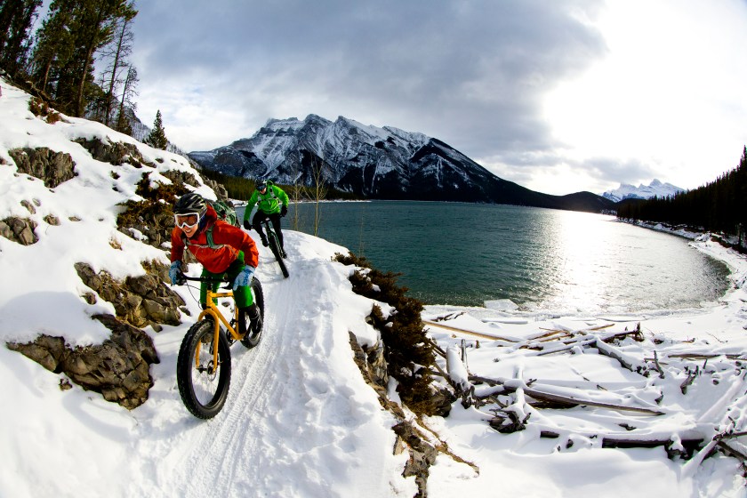 A woman and man enjoy a winter fat bike ride in Banff National Park (Getty Images)