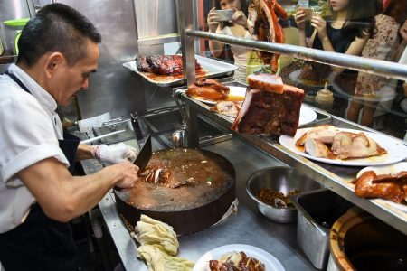 This photo taken on July 26, 2016 shows Singaporean hawker Chan Hon Meng chopping braised chicken at his Hong Kong Soya Sauce Chicken Rice and Noodle stall in Singapore.
Chan is one of two "hawkers" -- so-called because many started out as street peddlers -- awarded one star by the culinary bible Michelin, when it launched its inaugural Singapore guide in late July. / AFP / ROSLAN RAHMAN / TO GO WITH Lifestyle Singapore food Michelin,FEATURE by Elizabeth Law        (Photo credit should read ROSLAN RAHMAN/AFP/Getty Images)