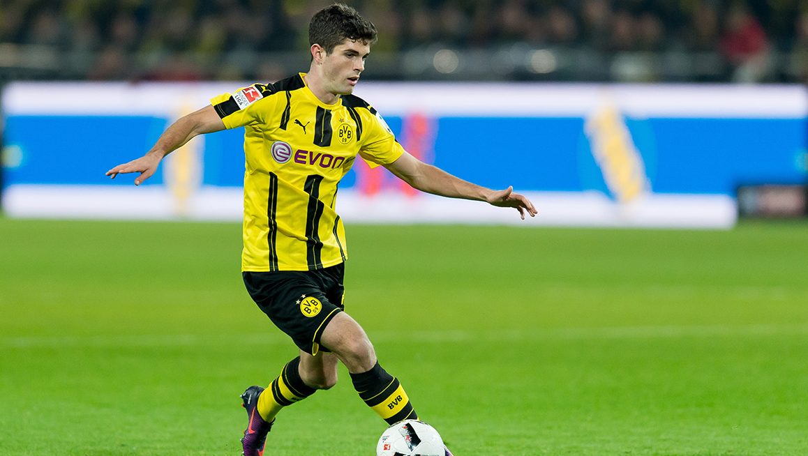 Christian Pulisic dribbles the ball for Borussia Dortmund in a Bundesliga game against FC Schalke. (TF-Images/Getty Images)
