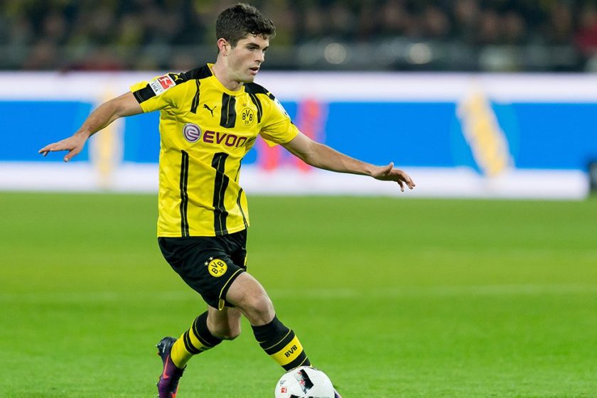 Christian Pulisic dribbles the ball for Borussia Dortmund in a Bundesliga game against FC Schalke. (TF-Images/Getty Images)