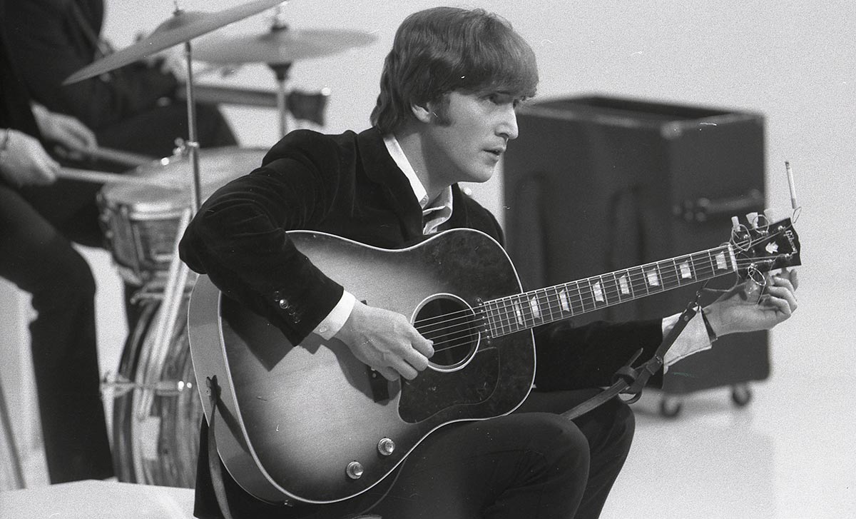 UNSPECIFIED - CIRCA 1960:  Photo of BEATLES and John LENNON; of the Beatles, tuning guitar (Gibson J160E acoustic) during the filming of "A Hard Day's Night" at the Scala Theatre  (Max Scheler - K & K/Redferns)