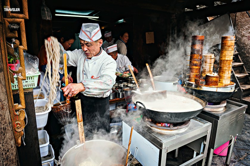 Cooks in downtown Chengdu keep busy preparing some of Sichuan’s famed specialties: hot-and-sour rice noodles and steamed dumplings. (Courtesy National Geographic Traveler)