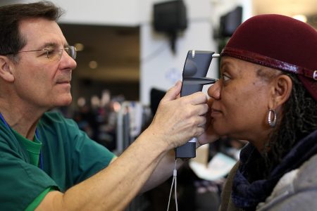 Mary Sanders (R) has her eyes examined by a Remote Area Medical (RAM) volunteer optometrist John Weis during a free clinic held at the Oakland-Alameda County Coliseum on April 11, 2011 in Oakland, California. (Justin Sullivan/Getty Images)