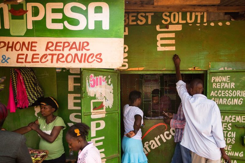 Residents transfer money using the M-Pesa banking service at a store in Nairobi, Kenya, on Sunday, April 14, 2013. In the six years since Kenya's M-Pesa brought banking-by-phone to Africa, the service has grown from a novelty to a bona fide payment network. Photographer: Trevor Snapp/Bloomberg via Getty Images