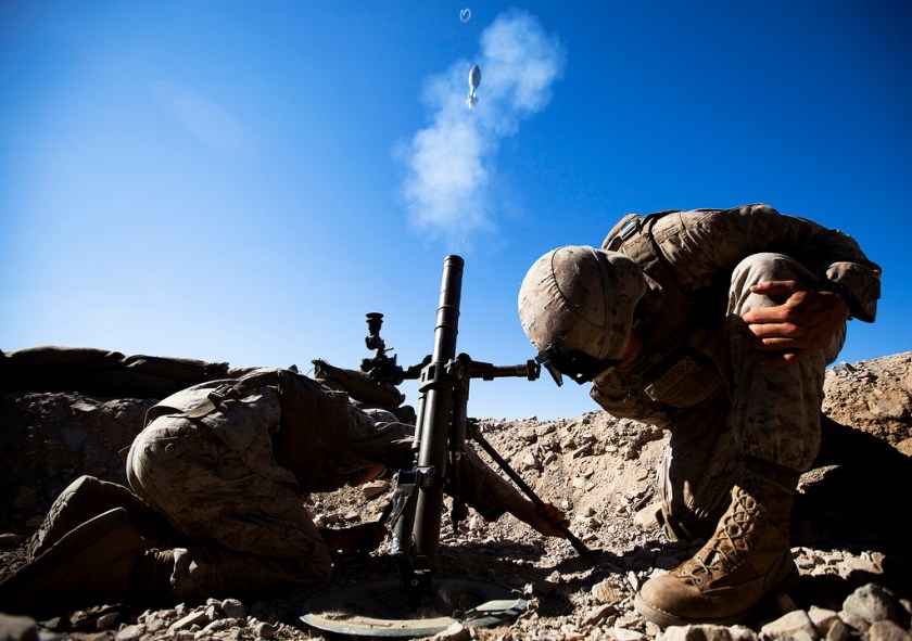 U.S. Marine Corps Lance Cpl. Justin Downing and Lance Cpl. Patrick Walker, mortar men with the 3rd Battalion, 3rd Marine Regiment, brace themselves while firing a 60mm mortar round during Exercise Clear, Hold, Build 3 on Marine Corps Air Ground Combat Center Twentynine Palms, Calif., Sept. 21, 2011. (DoD photo by Cpl. Reece Lodder, U.S. Marine Corps/Released)