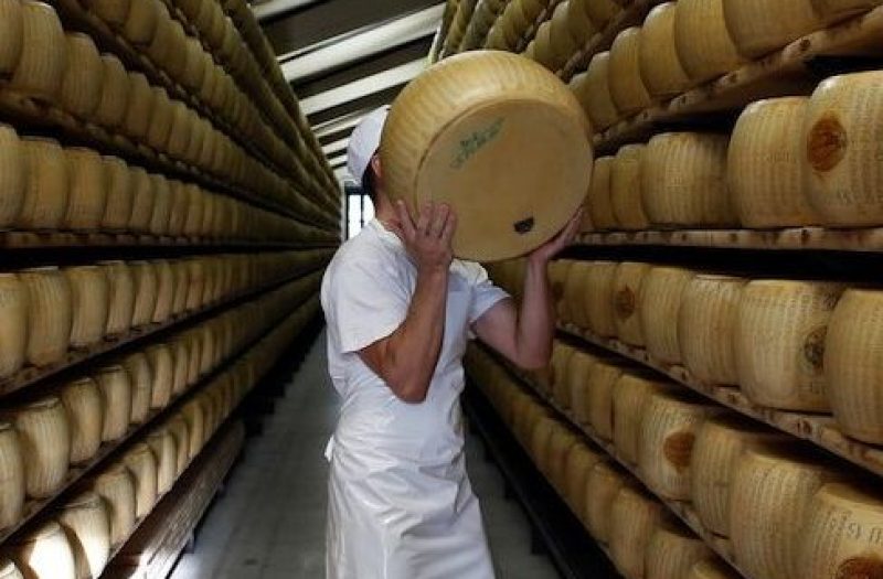 Bloomberg's Best Photos 2014: A worker selects a whole Parmigiano-Reggiano cheese from a storage rack ahead of inspection at Coduro cheesemakers in Fidenza, Italy, on Thursday, Sept. 11, 2014. Russian stores have run out of imported salmon and cheeses such as Parmigiano-Reggiano, Camembert and Brie, leading retailers like Metro AG's Cash & Carry unit to look for replacements, according to an e-mailed statement. Photographer: Alessia Pierdomenico/Bloomberg via Getty Images