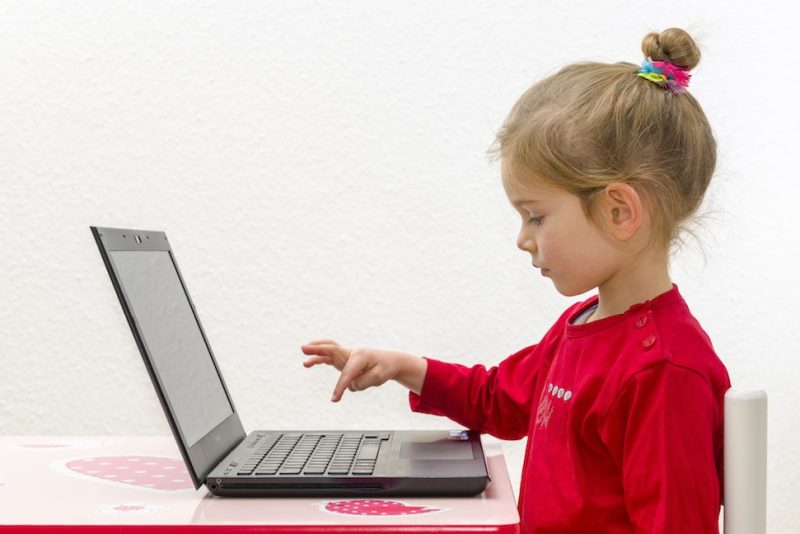 WUERZBURG, BAVARIA, GERMANY - 2014/12/21: A blond three year old girl is sitting in front of a notebook, laptop, watching the screen and using the keyboard. (Photo by Frank Bienewald/LightRocket via Getty Images)