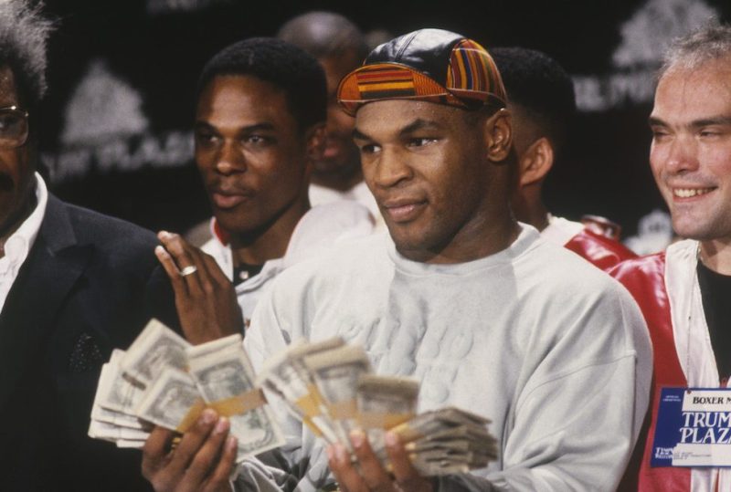 UNDATED: Mike Tyson holds two fists full of money and poses for cameras next to Don King during a press conference. (Photo by Focus on Sport/Gettty Images) *** Local Caption *** Mike Tyson;Don King